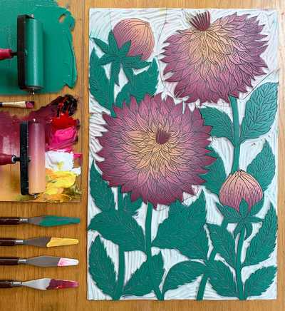 Flatlay of a floral vinyl carving and the paint applied
