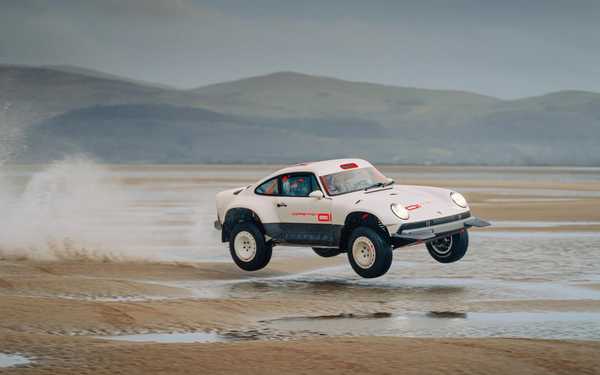 Car on the beach, doing a jump in the sand