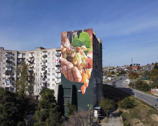 Mural of hands holding fruit on the side of a building