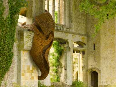 Photo of a weaved wooden sculpture hanging from a castle wall