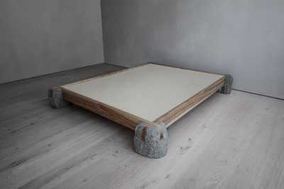 Sculptural bed frame made of wood and stone