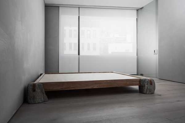 Sculptural bed frame made of wood and stone