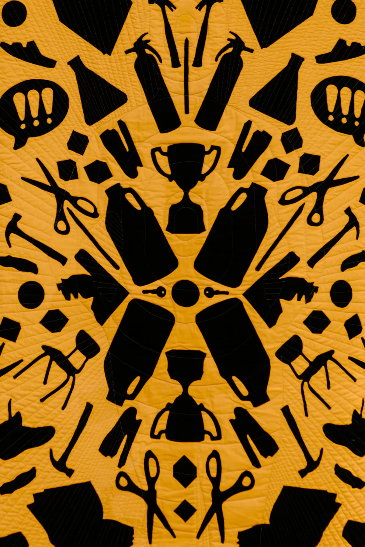 A quilt featuring silhouettes of a variety of school supplies which can be used as weapons